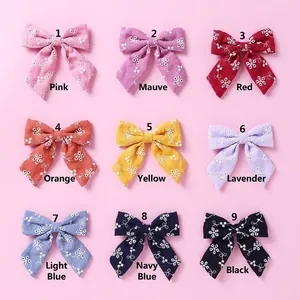 Détail de 9 barrettes en coton coloré avec de délicates broderies florales blanches