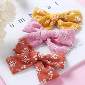 Set of three embroidered cotton lace hair bows in yellow, pink and caramel colors