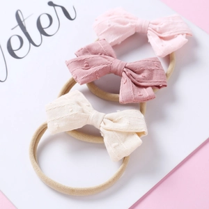 Detailed set of 3 soft jacquard bow headbands for babies in light pink and beige