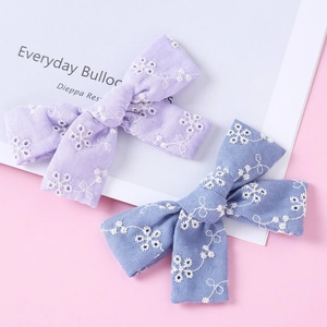 Embroidered cotton bow hair clips in purple and blue with delicate floral patterns