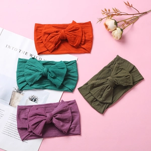 Detail view of soft nylon infant headbands with large double layer bows in four colors