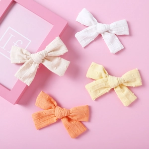 Set of four textured cotton jacquard bow hair clips for baby girls in pastel colors