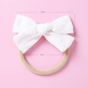 Détail d'un bandeau bébé avec nœud en dentelle de 10 cm et élastique en nylon souple