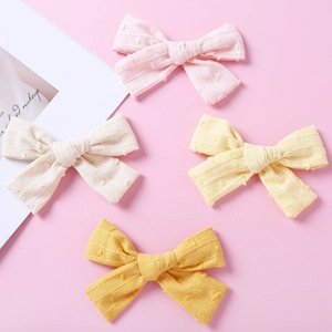 Minimalist jacquard cotton bow hair clips in four pastel colors for infants and children
