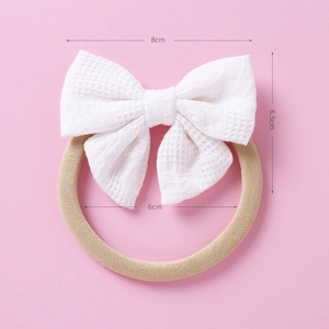 Vue détaillée du bandeau pour bébé avec nœud en dentelle blanche et mesures