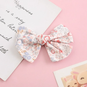 Floral cotton bow hair clip with pink and blue blossoms on a soft white background