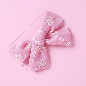 Detailed view of pink embroidered lace bow hair clip showing 10cm by 6cm dimensions