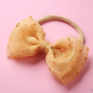 Détail d'un bandeau pour bébé en maille pêche avec nœud et tissu en nylon extensible