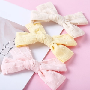 Three-piece set of cotton jacquard textured bow hair clips in soft pink yellow and beige