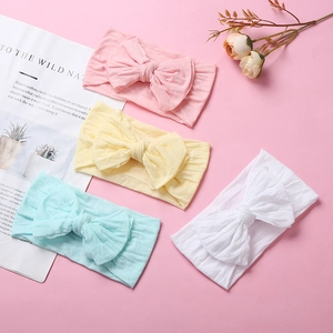 Set of four soft nylon bow headbands for babies in pink, yellow, mint, and white colors