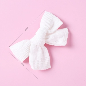 Top view of handmade white waffle texture cotton bow hair clip measuring 10x6 cm