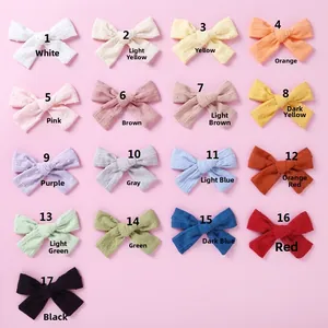 Detail showing 17 colors of jacquard cotton bow hair clips with Swiss dot texture