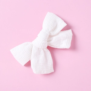 Close-up detail of white cotton waffle texture on handmade bow hair clip for girls