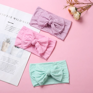 Detailed set of three soft nylon baby headbands with large bows in pastel colors