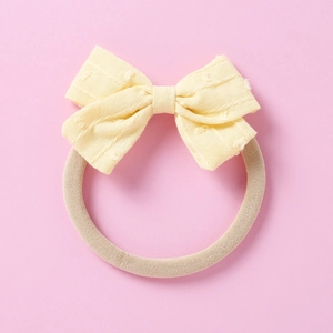 Detail view of yellow jacquard bow headband with textured cotton and soft nylon elastic