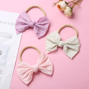 Trois bandeaux bébé en nylon souple avec nœuds en tissu en lilas, blanc crème et rose