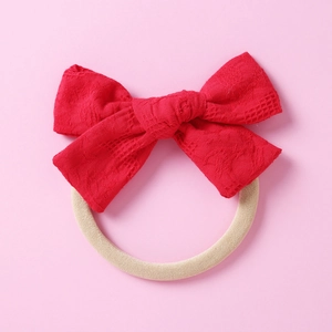 Détail macro du bandeau à nœud en dentelle rouge avec bande en coton sans couture