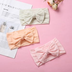 Detailed view of three soft nylon baby headbands with double-layered bows in pastel colors