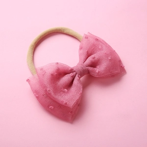 Détail du bandeau rose à nœud avec points texturés et bande en nylon souple pour bébés