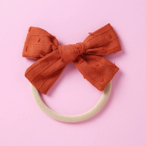 Nahaufnahme der rostorangen Jacquard-Schleife mit weichem Nylon-Haarband für Babys
