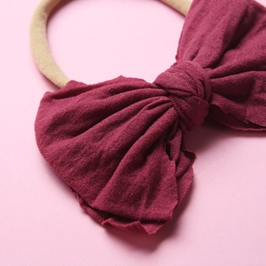 Gros plan détaillé d'un bandeau à nœud rouge vin en coton texturé doux et nylon