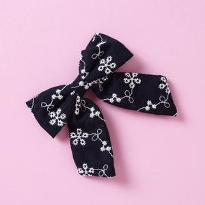Gros plan détaillé d'un nœud papillon en coton bleu marine avec broderie florale