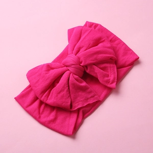 Detailed view of soft rose pink nylon baby headband with a large layered knot bow