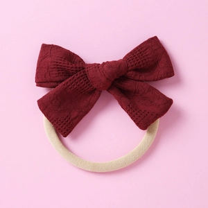 Détail du nœud en dentelle rouge foncé sur bandeau élastique doux pour bébés