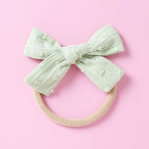 Detail eines mintgrünen Jacquard-Schleifen-Stirnbands mit weichem Nylonband für Babys