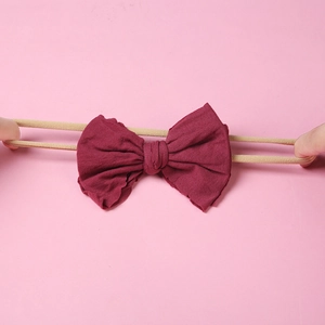 Gros plan montrant la haute élasticité et l'étirement du bandeau bébé avec nœud en nylon