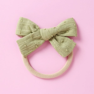Detail eines Baby-Nylon-Stirnbands mit salbeigrüner strukturierter Baumwollschleife