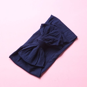 Detail shot of the soft navy blue nylon fabric and textured double-layer bow headband