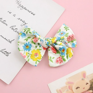 Close-up of floral print cotton bow clip with vibrant blue and yellow petal patterns