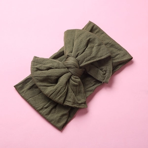 Detail of army green nylon bow headband with soft double-layered knotted texture