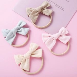 Détail du lot de quatre bandeaux bébé avec nœuds tricotés en couleurs douces pastel