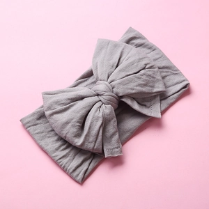 Detailed texture of gray nylon bow headband with soft stretch fabric for infants