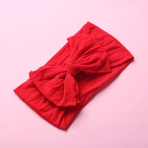 Detailed view of wide soft nylon headband with large red bow for babies and toddlers