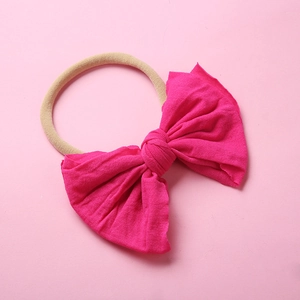 Vue détaillée du bandeau bébé en maille rose avec nœud doux et nylon élastique nude