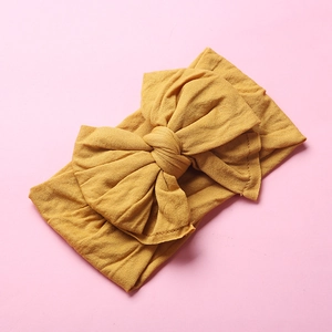 Detailed macro view of the ginger yellow nylon baby headband with wide pleated fabric texture
