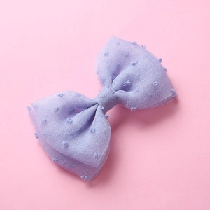 Détail d'une pince à cheveux nœud en tulle lavande avec petits pois floqués en relief