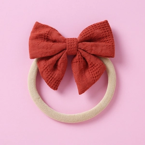 Détail du bandeau jacquard rouge rouille pour bébé avec sangle en nylon élastique