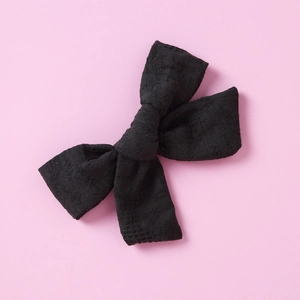 Close-up of black lace bow hair clip featuring intricate floral mesh patterns for girls