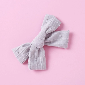 Detailed close-up of lilac cotton jacquard bow hair clip with Swiss dot texture
