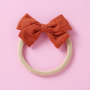 Detail showing the rust red jacquard bow fabric and high elastic seamless soft nylon headband