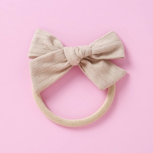 Détail d'un bandeau bébé en coton gaufré avec nœud et bande élastique souple