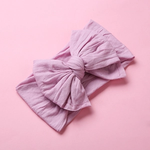 Detail showing soft nylon fabric and large double-layer bow on baby headband