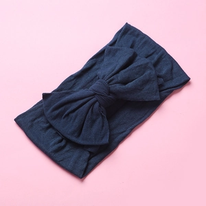 Detailed texture of dark blue soft nylon headband with large double-layered bow for babies