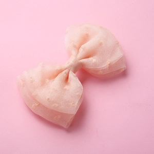 Détail d'une pince à cheveux en tulle rose clair à pois 3D pour petites filles