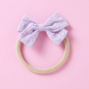 Detail of lilac jacquard bow headband with white dot texture on soft elastic nylon band