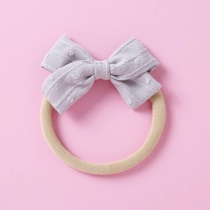 Detail of lavender jacquard bow headband for infants with elastic nylon band